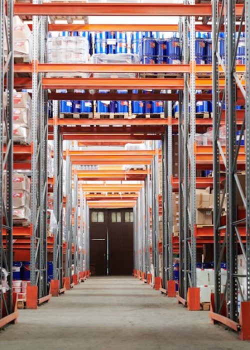 Wide angle view of a warehouse with stocked shelves and boxes.